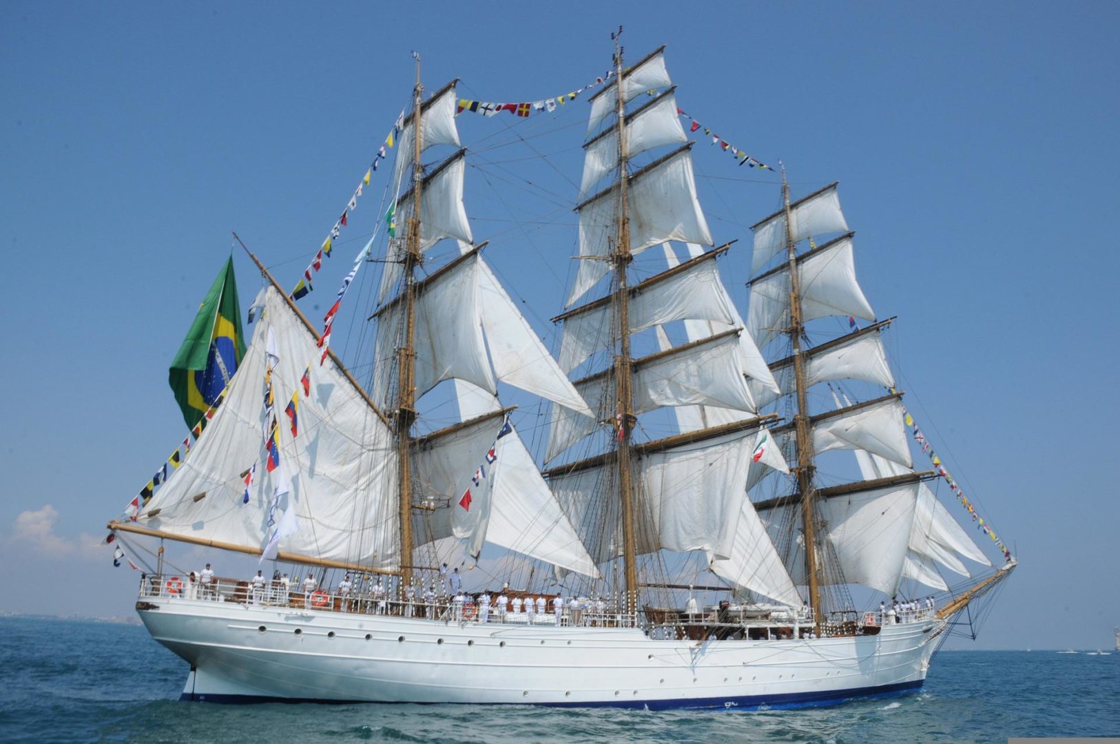 veleiro cisne branco navegando em mar e céu azul representando a navegação nas conquistas das oportunidades no mercado financeiro e de capitais