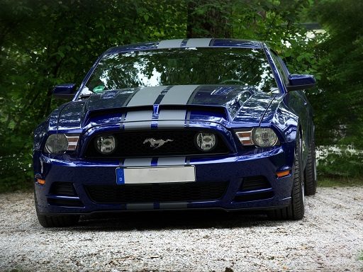 um mustang shelby azul de frente com duas faixas brancas no capô reppresentando os objetivos e sonhos de vida